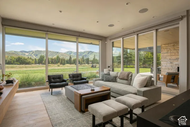 Floor-to-ceiling windows, sliding glass doors, built-in ceiling speakers, wood-finish flooring, and recessed lighting