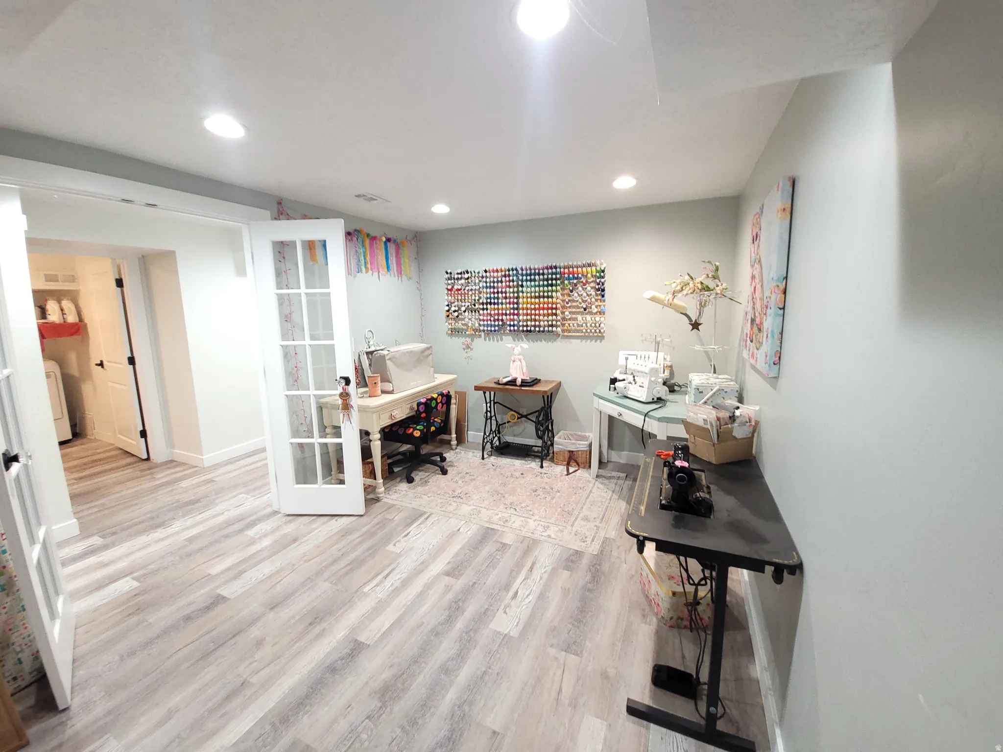 Versatile craft/office space featuring wood-finish flooring and recessed lighting