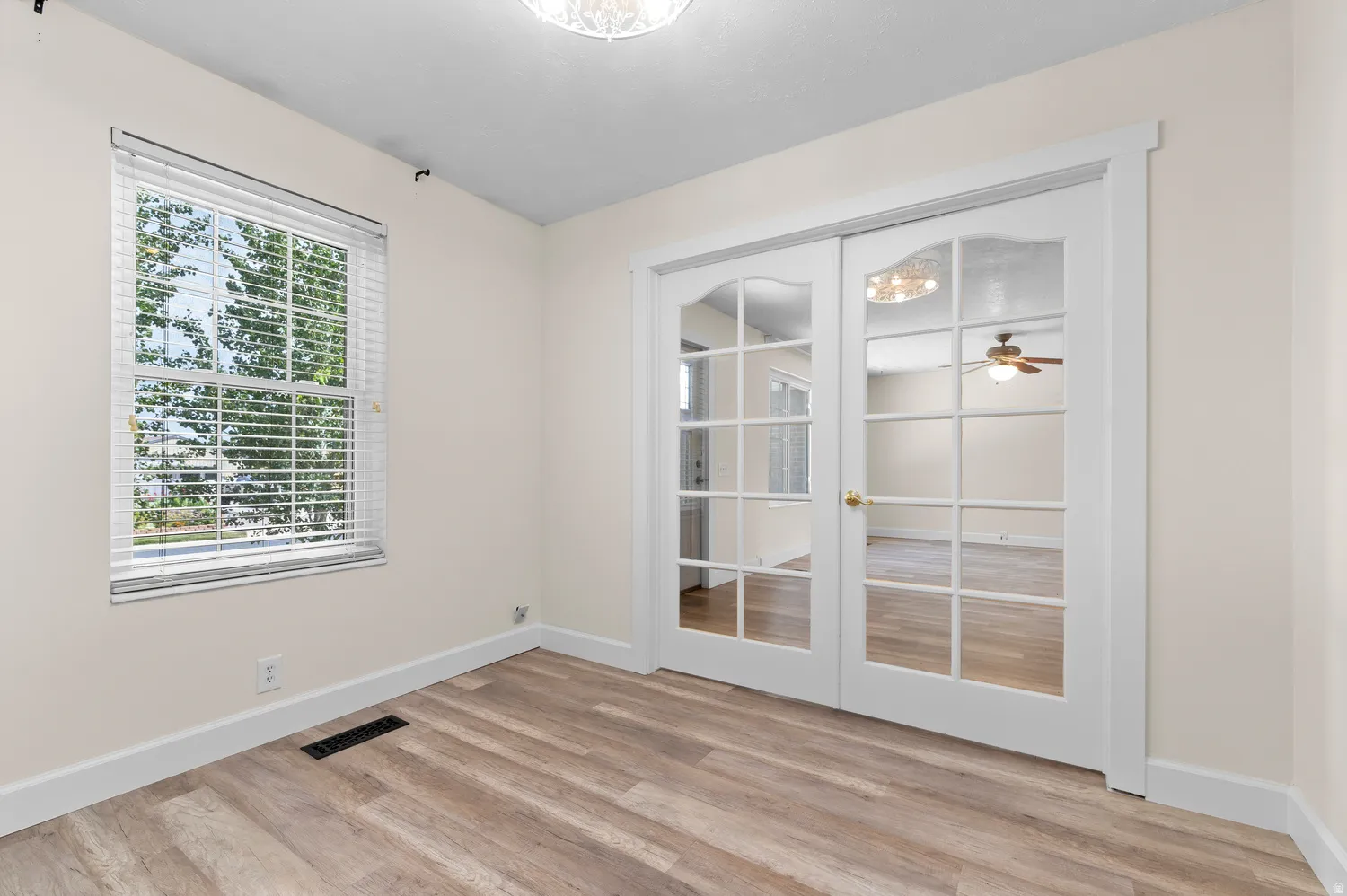 Office or 2nd Main Bed Room featuring wood-finish flooring, a double window with blinds, and white French doors