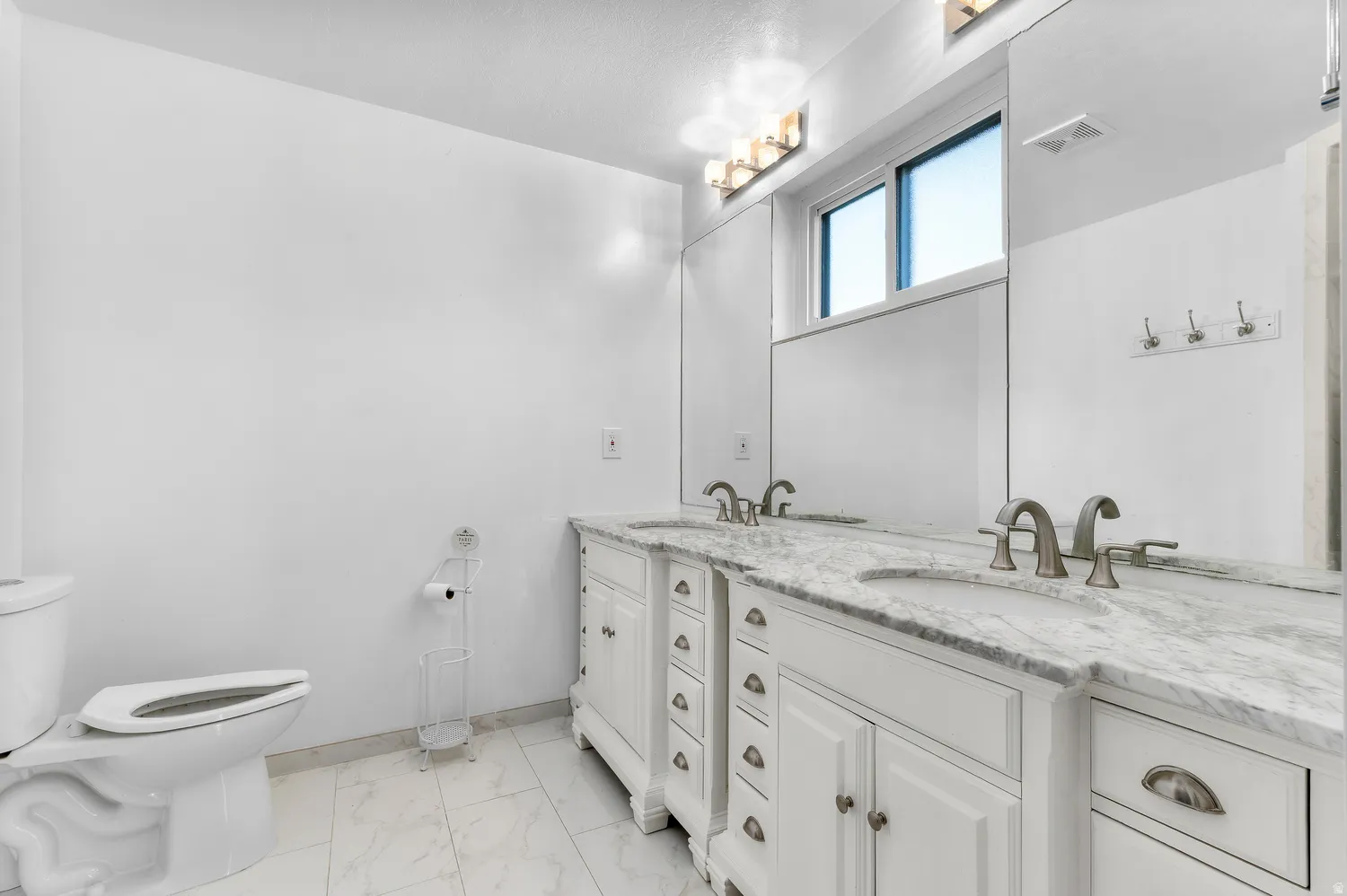 Master Dual vanity with white cabinetry, integrated sinks, and stone countertops
