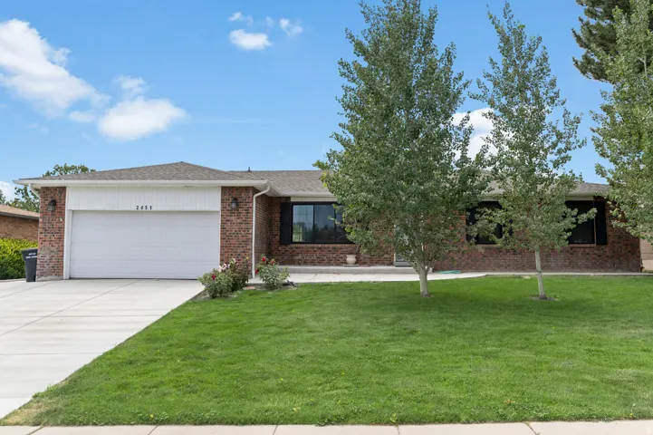 Brick exterior with white garage door and matching vertical siding