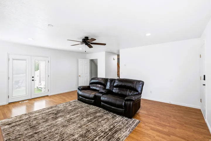 Spacious living room featuring laminate flooring, fresh bright white walls and French doors.