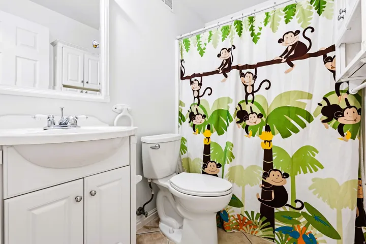 Full bathroom featuring a white vanity with integrated sink, white toilet, and tile flooring