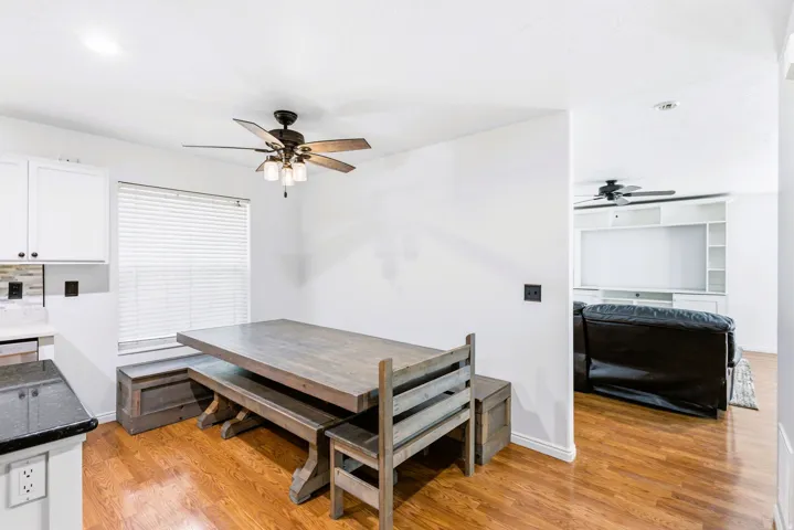 Kitchen nook with built-in bench seating, wood-finish flooring, and a ceiling fan