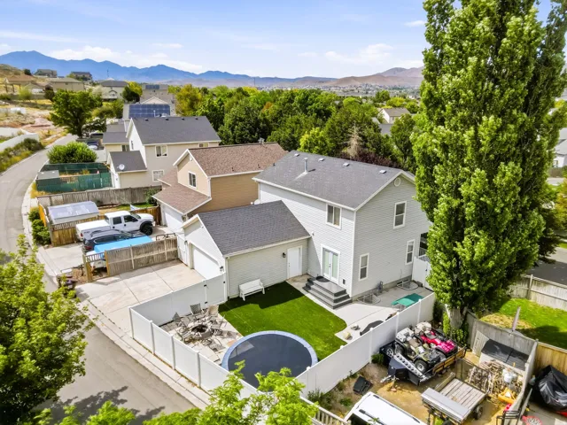 Aerial of backyard featuring artificial turf, oversized patio and fully fenced yard.
