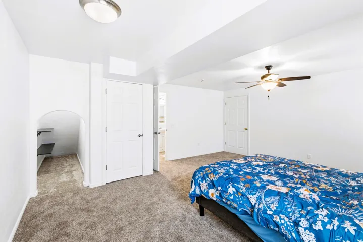 Bedroom #4 Spacious room featuring new carpet, a ceiling fan with integrated lighting, and multiple panel doors