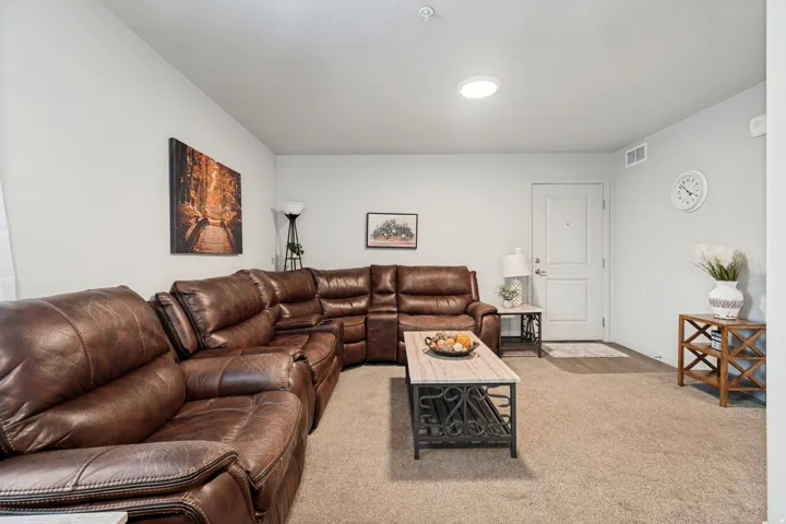 Living area featuring light neutral walls, recessed lighting, and carpeted flooring