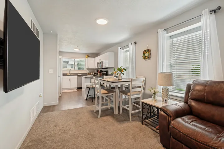 Open-concept living area with carpet flooring and ceiling-mounted lighting