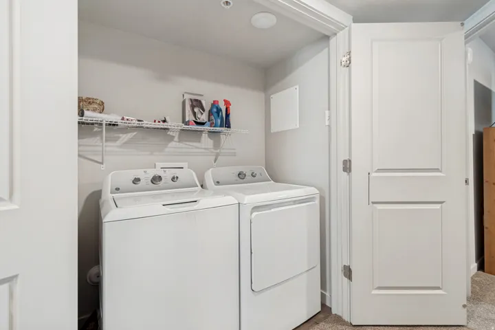 Dedicated laundry closet featuring a top-load washer, front-load dryer, and wire shelving