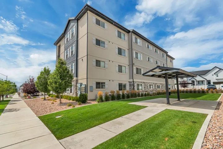 Contemporary multifamily building featuring a light-colored stucco exterior with dark vertical siding accents
