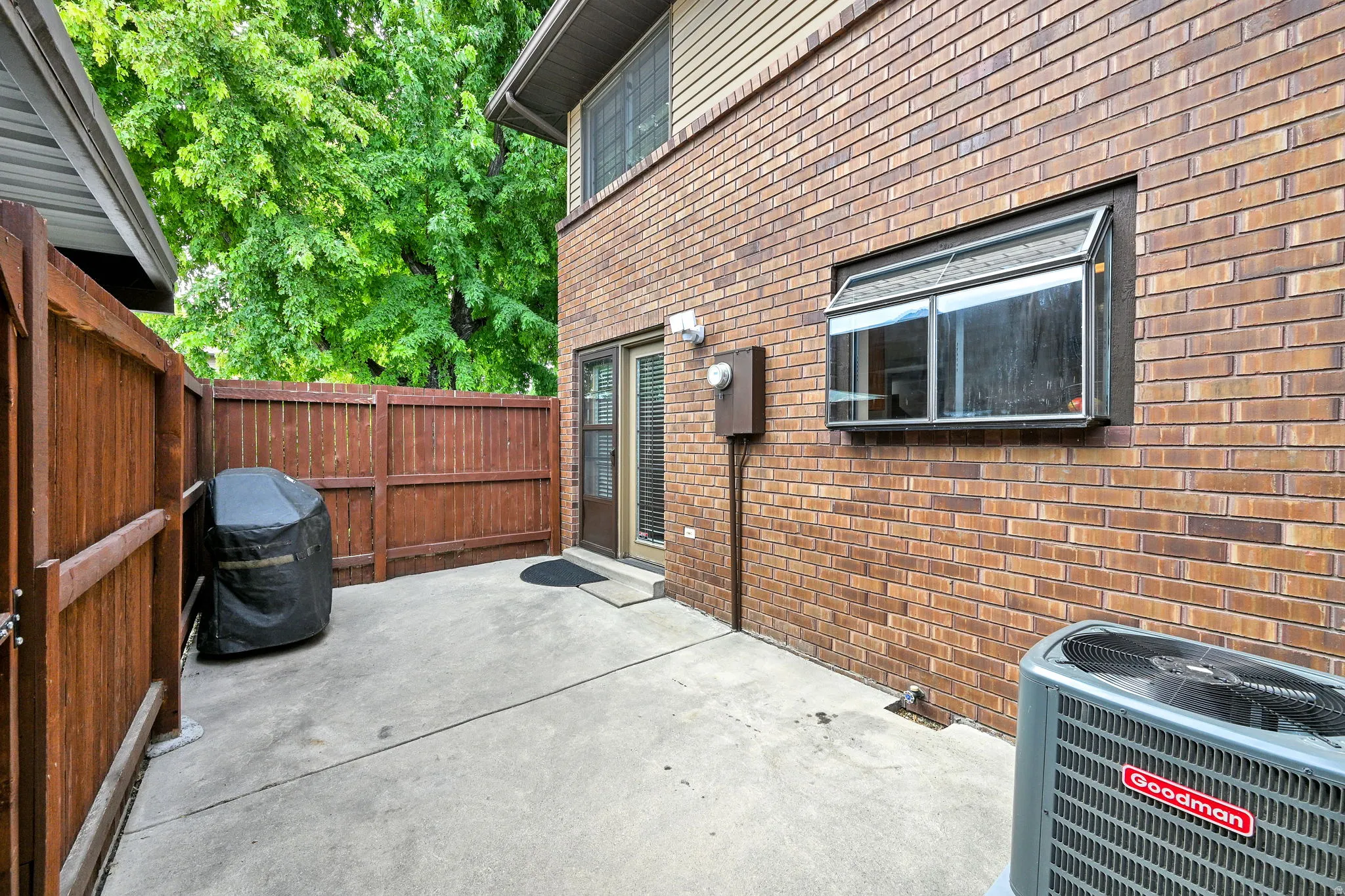 Private patio space featuring concrete flooring and a solid wood privacy fence