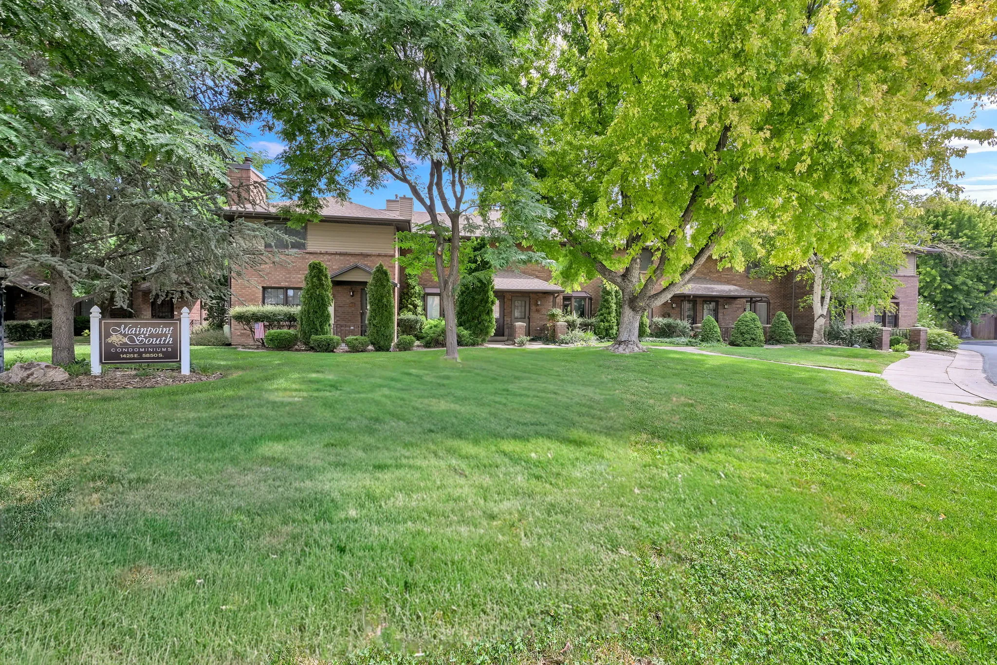 Brick exterior residences with a light-colored siding accent and a large manicured lawn