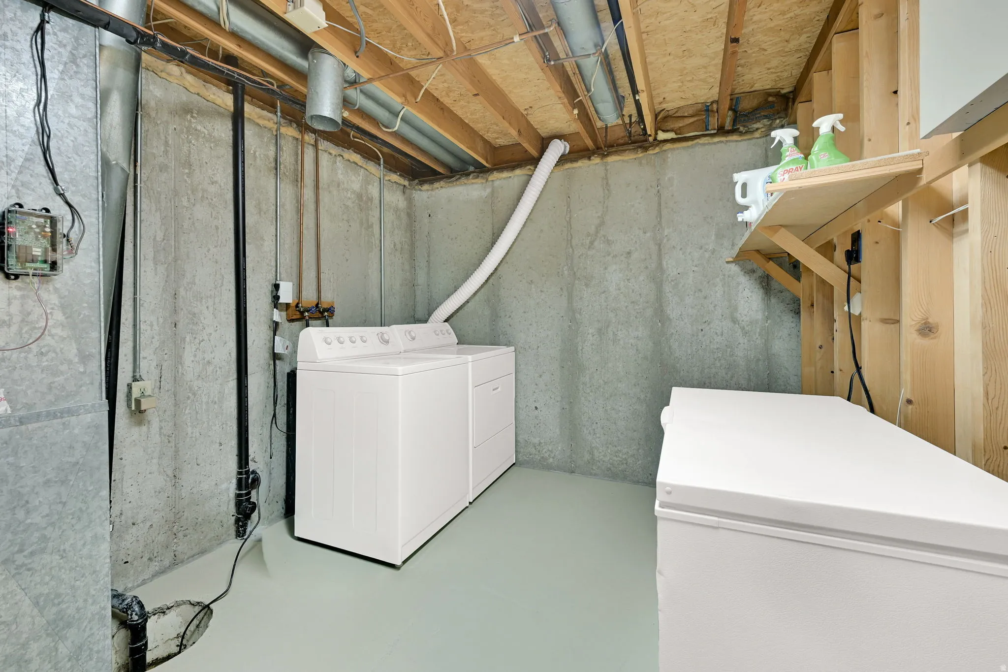 Basement utility area featuring exposed concrete walls and an unfinished wood ceiling