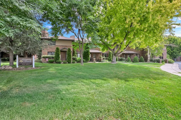 Brick exterior residences with a light-colored siding accent and a large manicured lawn