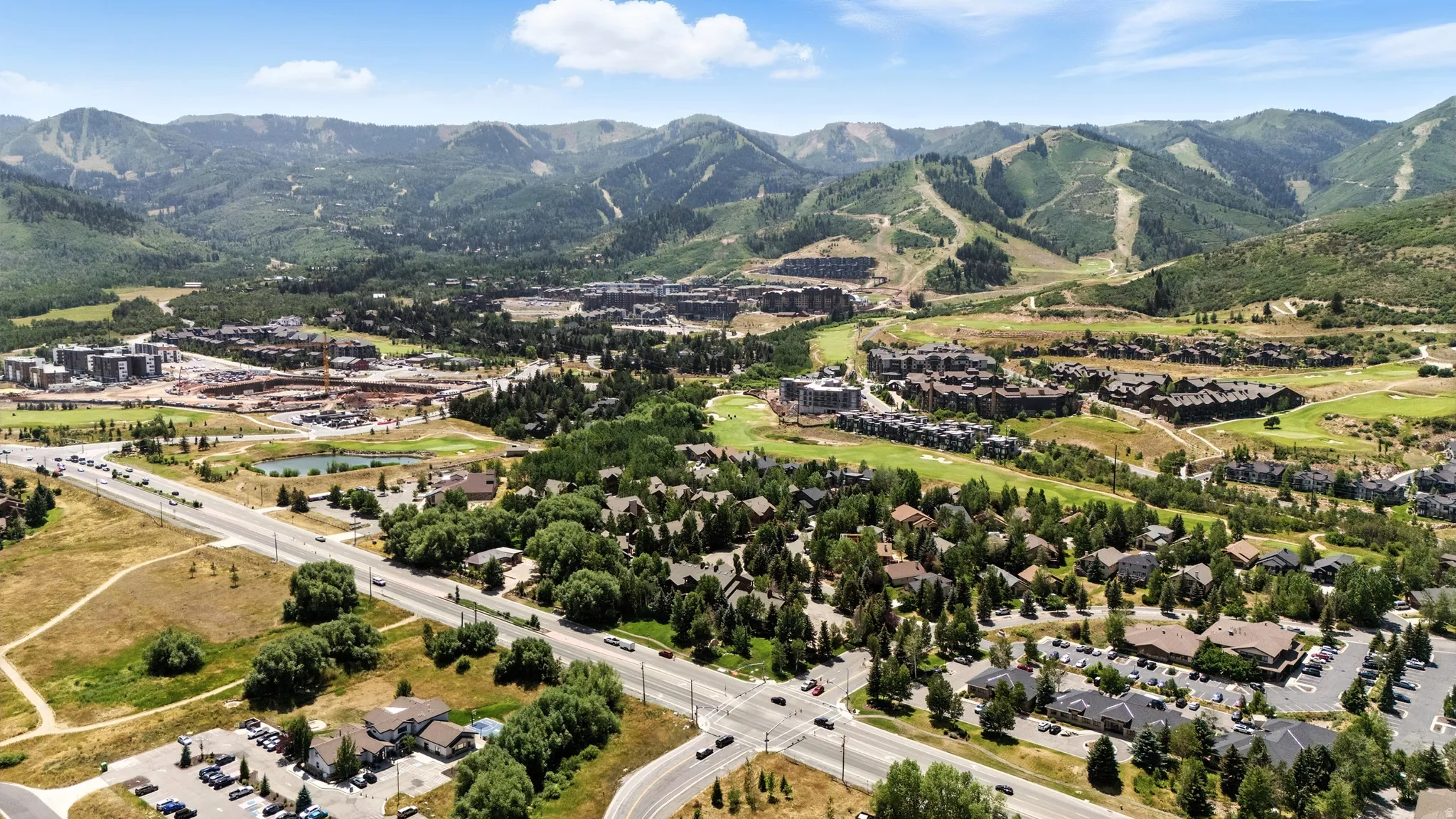 Expansive mountain landscape featuring residential properties, a golf course, and a highway
