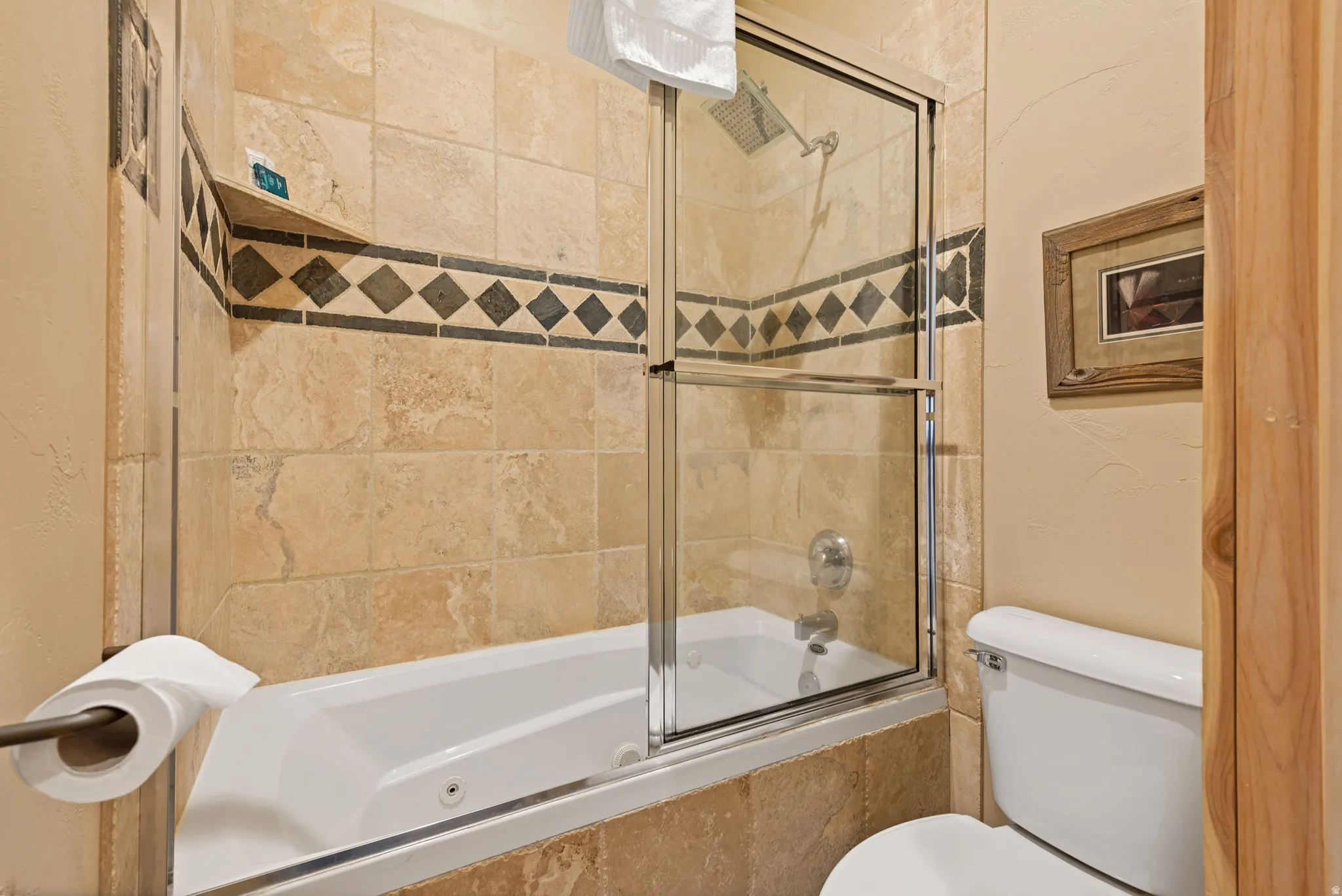 Tiled tub and shower combination featuring a rain showerhead, a separate handheld shower, and a built-in corner shelf