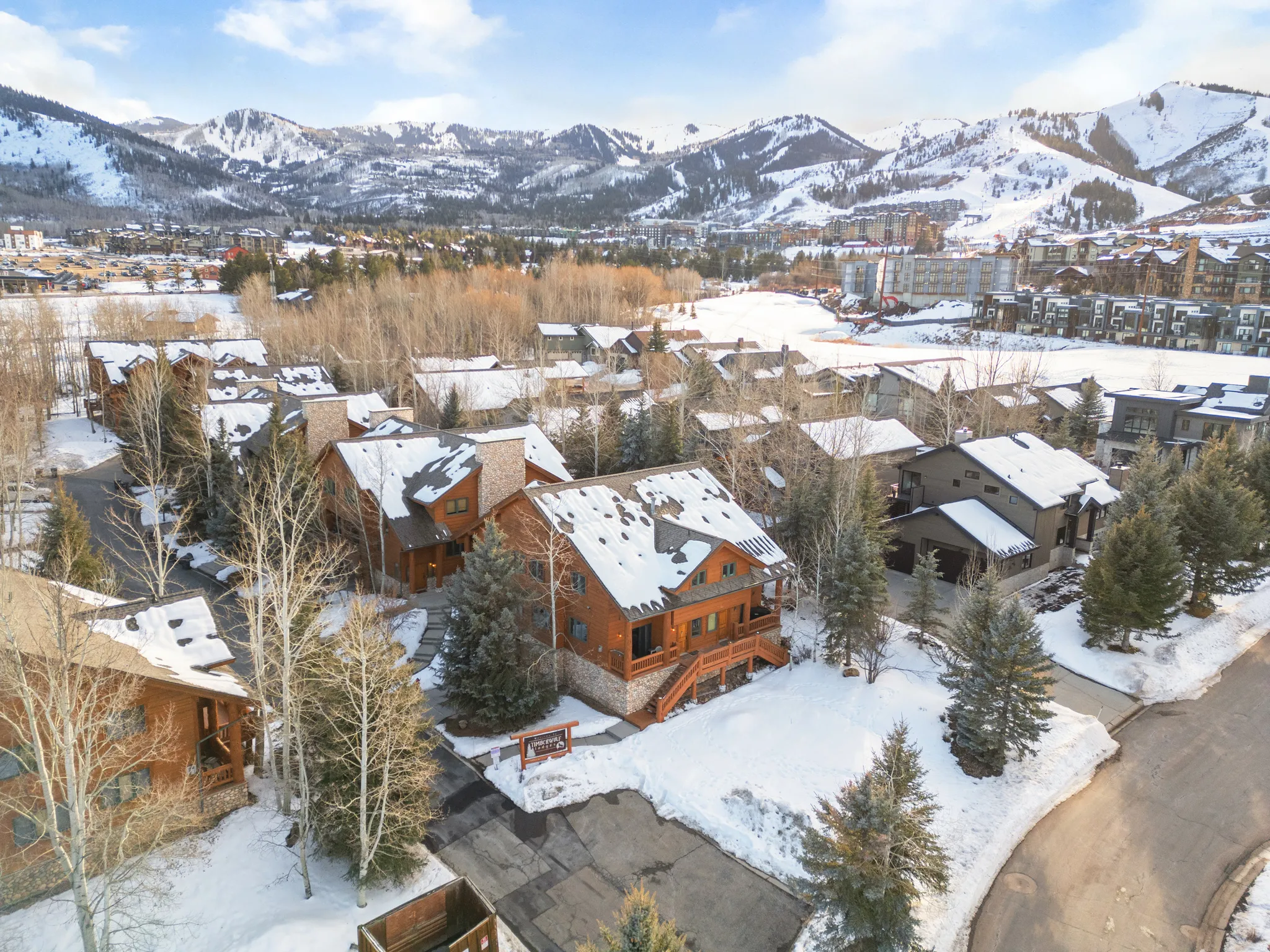 Wood-sided residence featuring a stone foundation and multiple gables