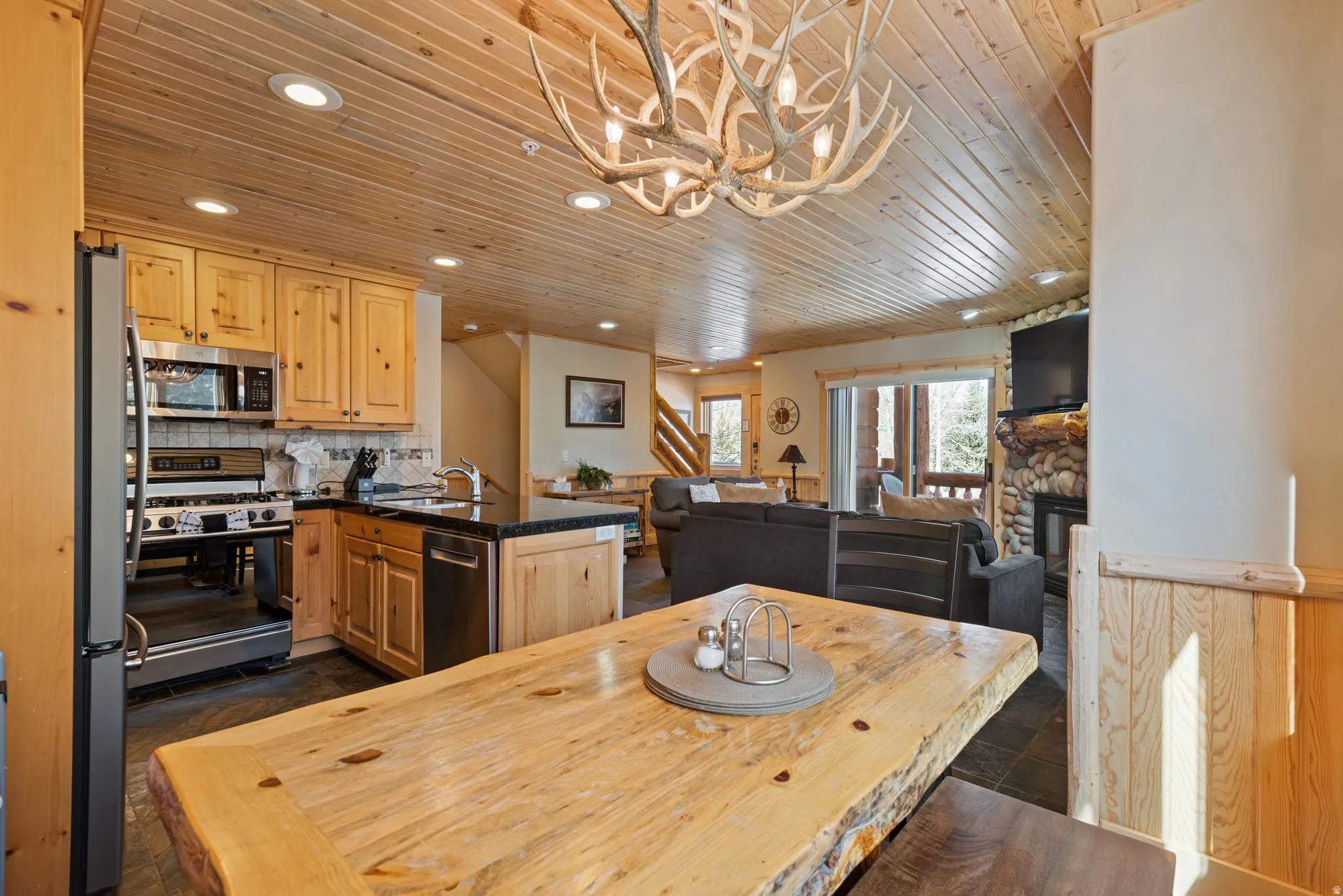 Open-concept living space with wood-paneled ceilings, recessed lighting, and wood-finish flooring