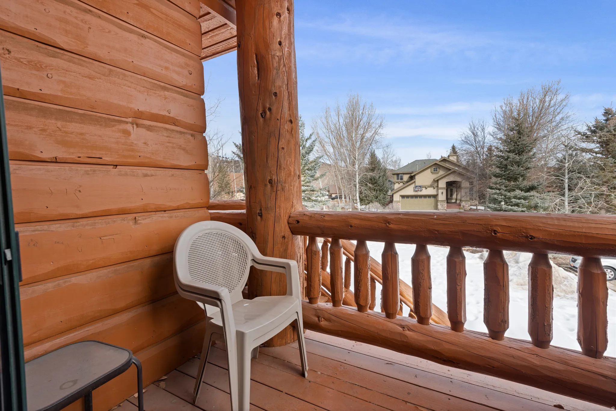 Exterior balcony featuring log construction, a log railing, and a wood-finish floor