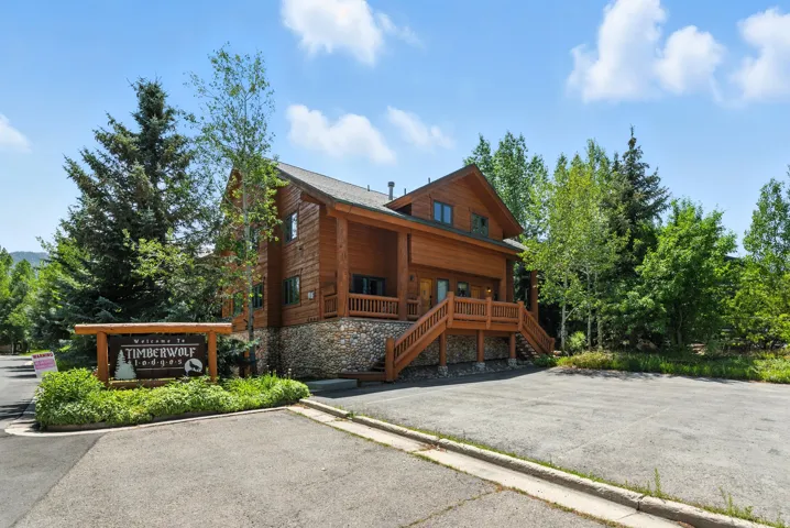 Rustic log-style exterior featuring a stone foundation and wood-finish railings
