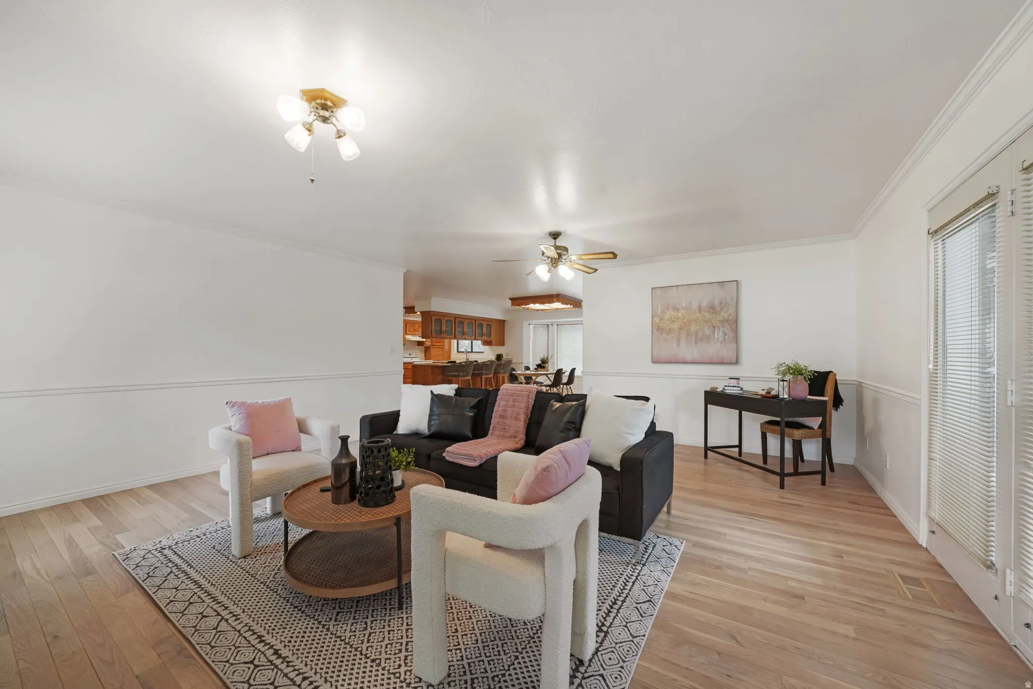 Light wood-finish flooring complements white walls and crown molding