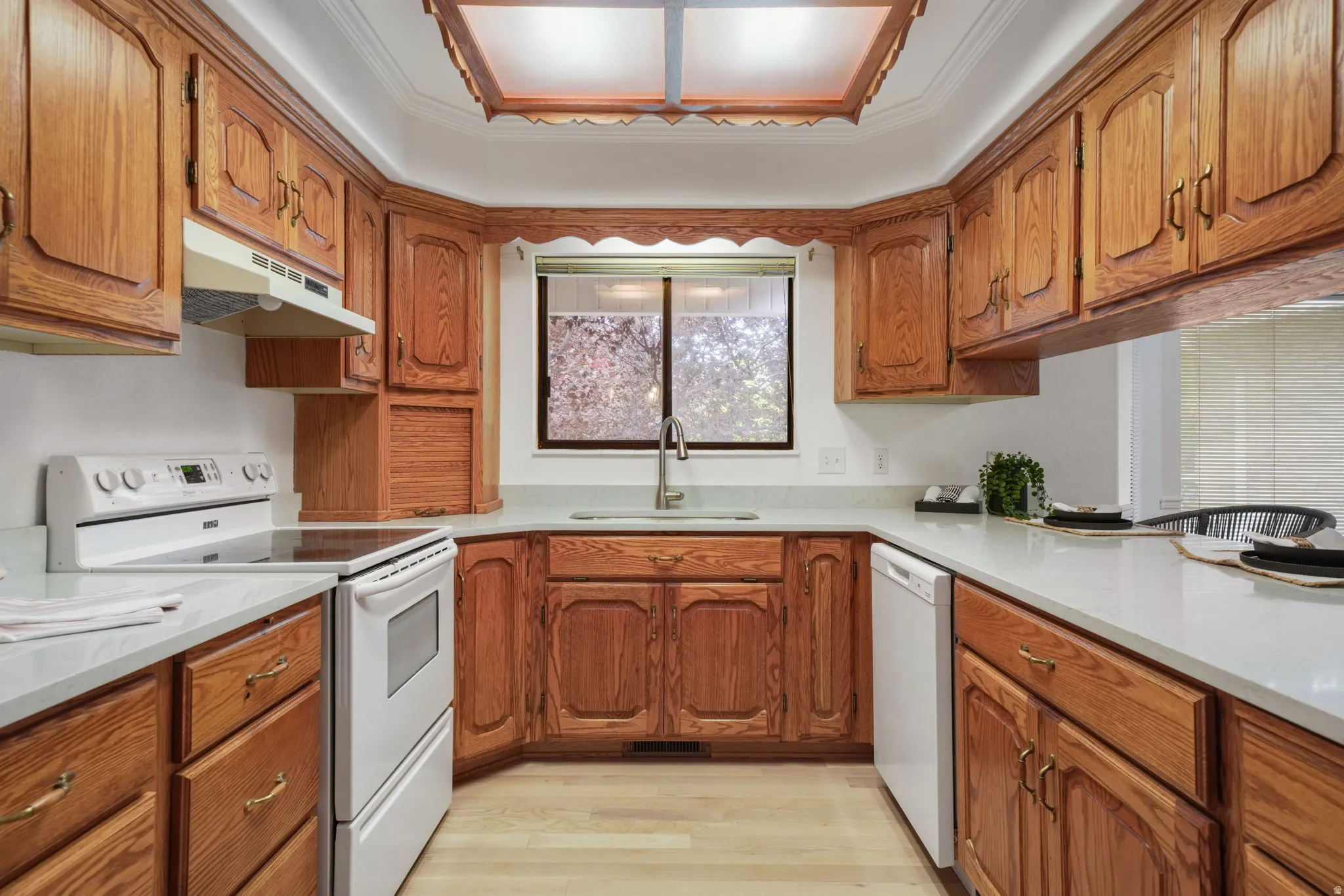 U-shaped kitchen with wood cabinetry and light countertops