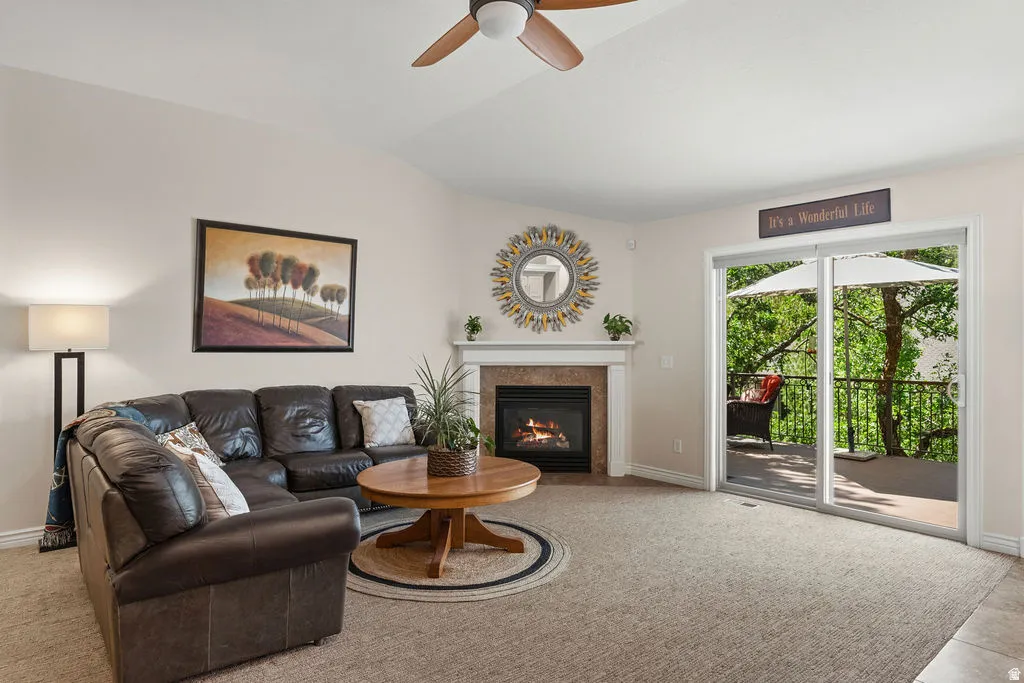 Living area featuring a corner fireplace with a white mantel and stone surround