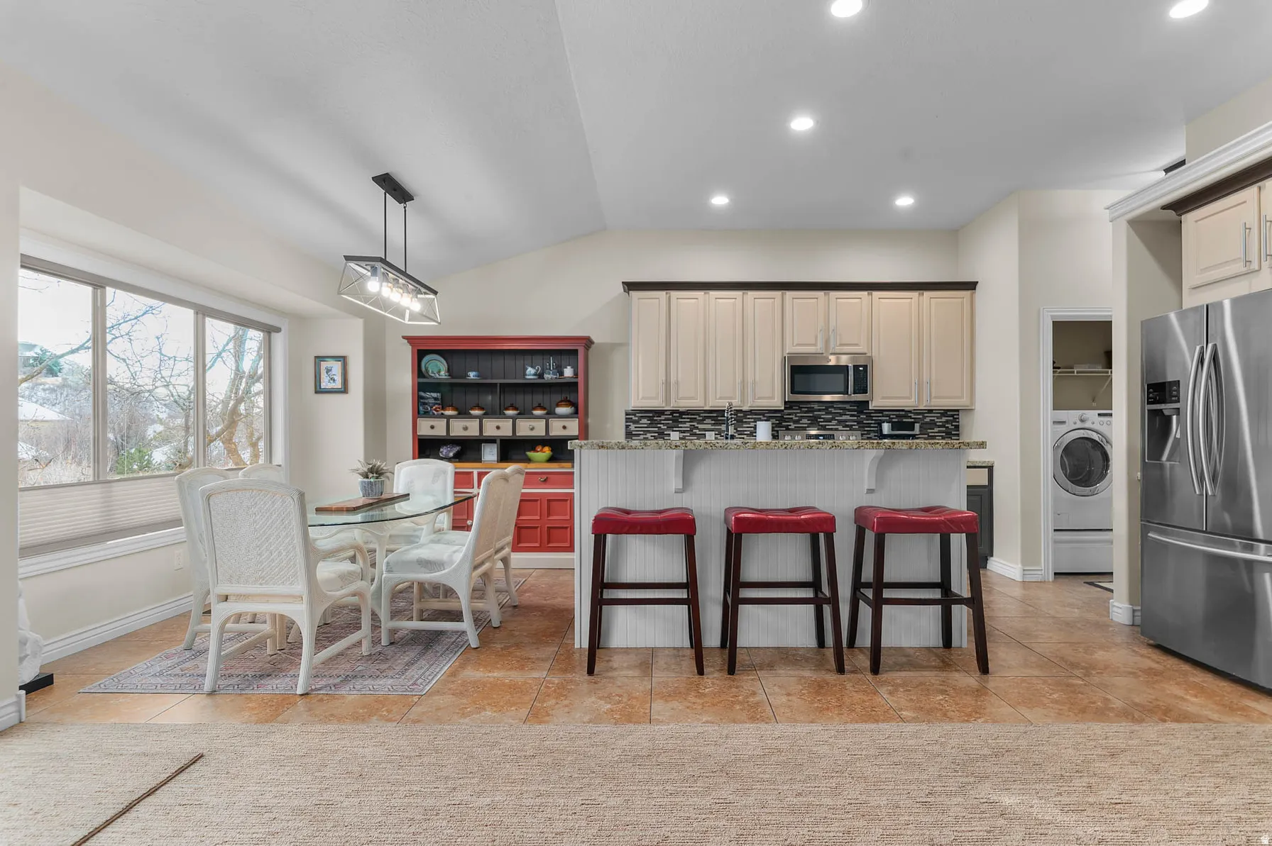 Kitchen dining area featuring a vaulted ceiling and tile flooring