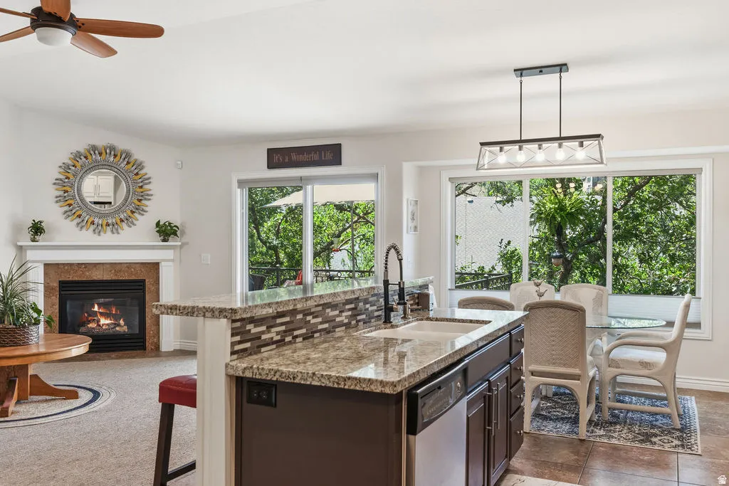 Kitchen island featuring an undermount sink with a gooseneck faucet, granite-style countertop, and mosaic tile backsplash