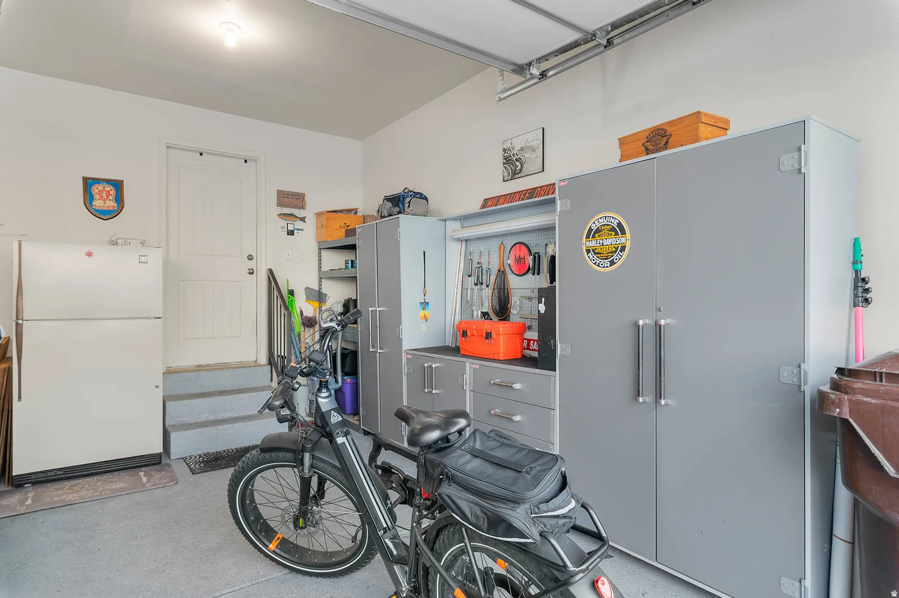 Spacious garage featuring a durable concrete floor, an overhead garage door track system, and built-in gray storage cabinetry