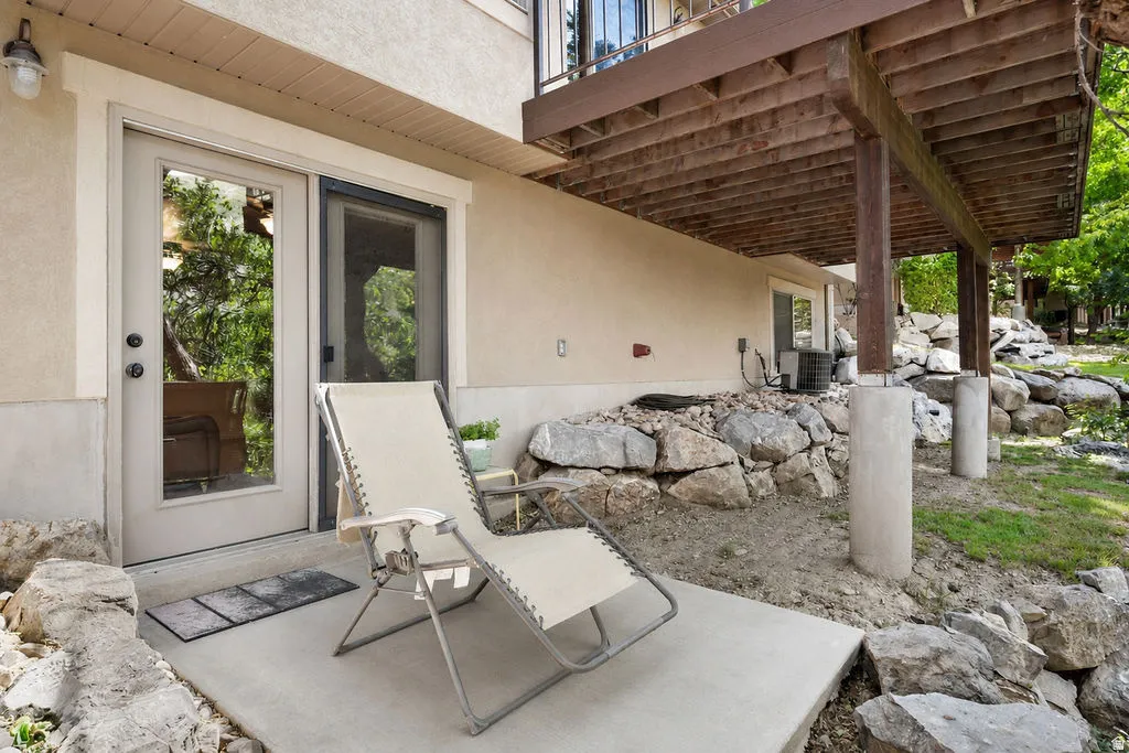 Ground-level patio with concrete slab, exterior double doors, and adjacent screening