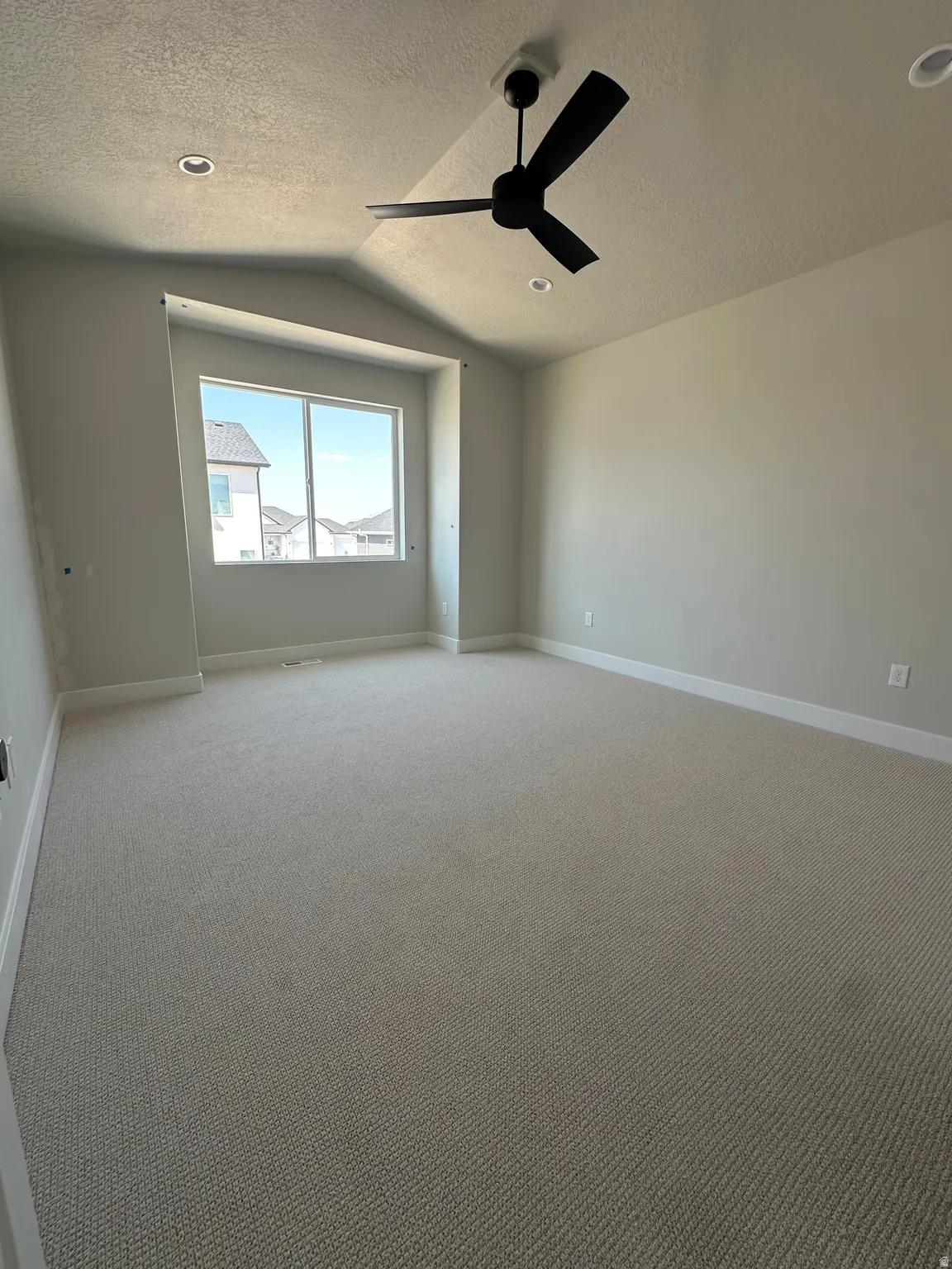 Spacious room featuring carpeting, recessed lighting, a ceiling fan, and a large window
