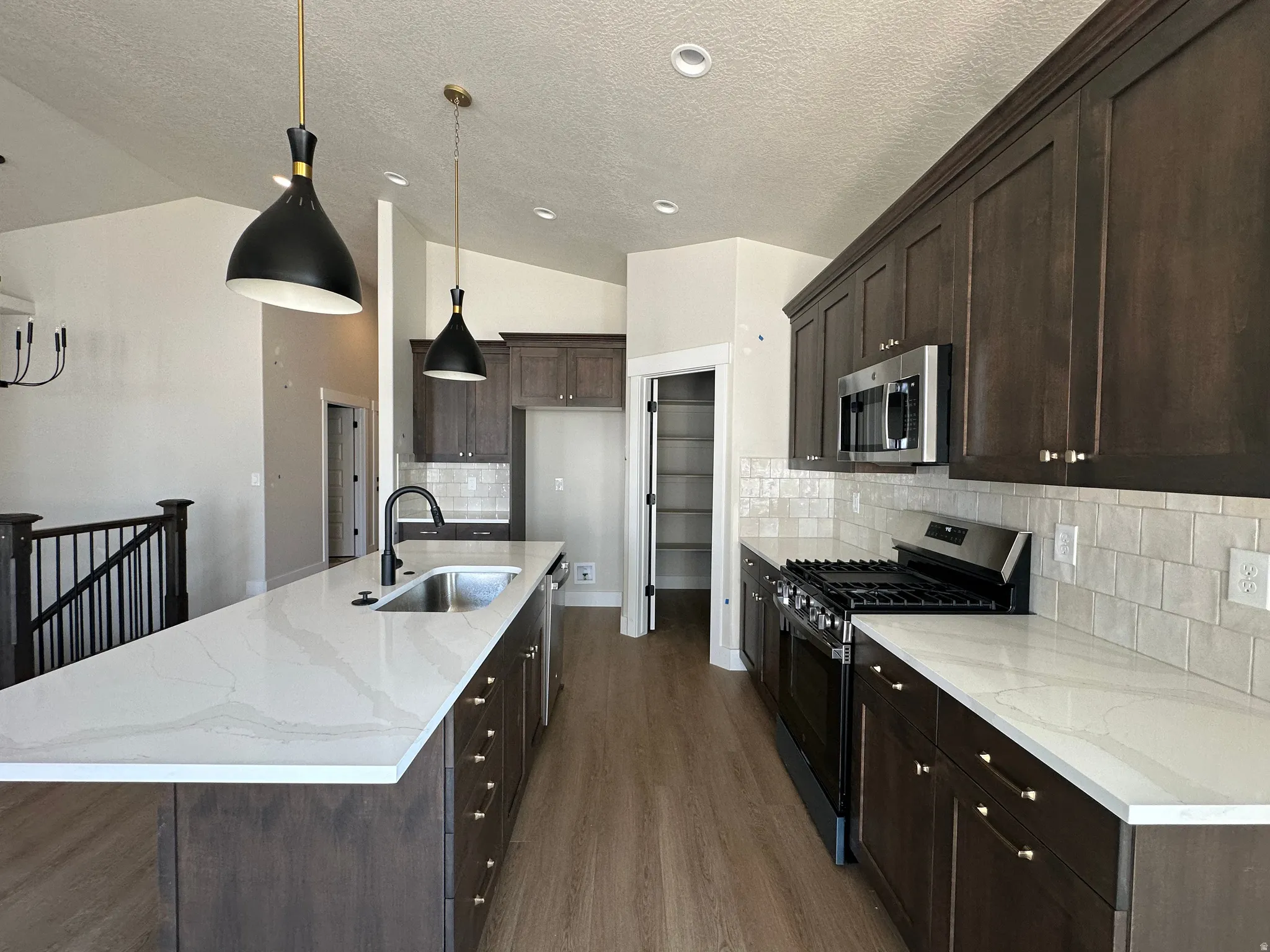Expansive kitchen island with a single basin sink, matte black faucet, and white countertop