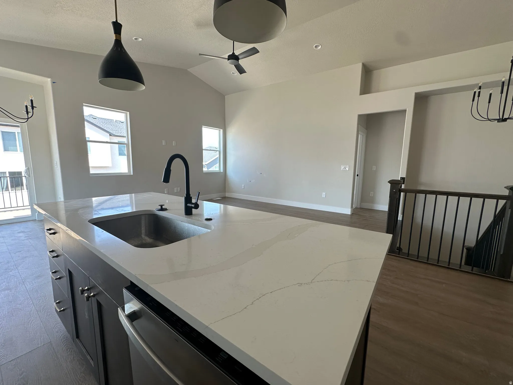 Kitchen island with a stainless steel sink, matte black faucet, and light-toned countertop
