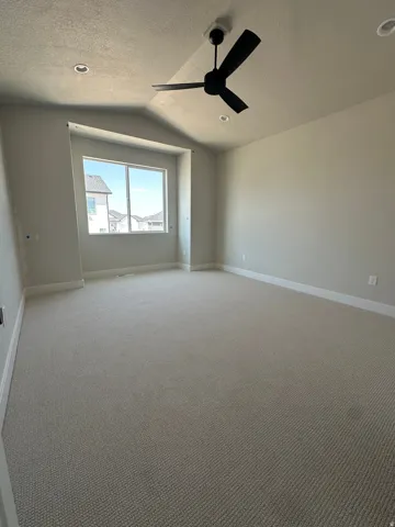 Spacious room featuring carpeting, recessed lighting, a ceiling fan, and a large window