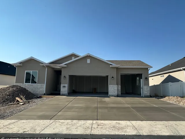 Contemporary stucco exterior featuring a stone facade and a two-car garage