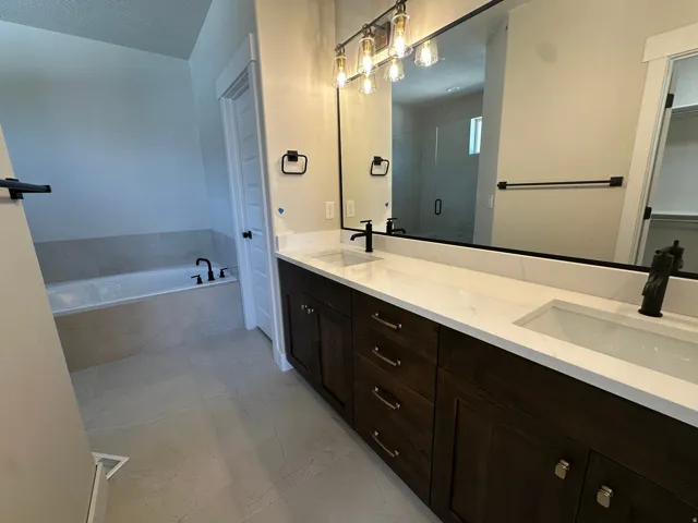 Dual vanity with white countertops, dark wood cabinetry, and rectangular undermount sinks