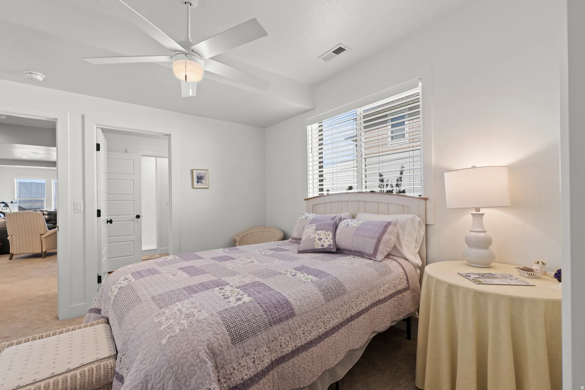 Bright bedroom featuring neutral wall tones and carpet flooring