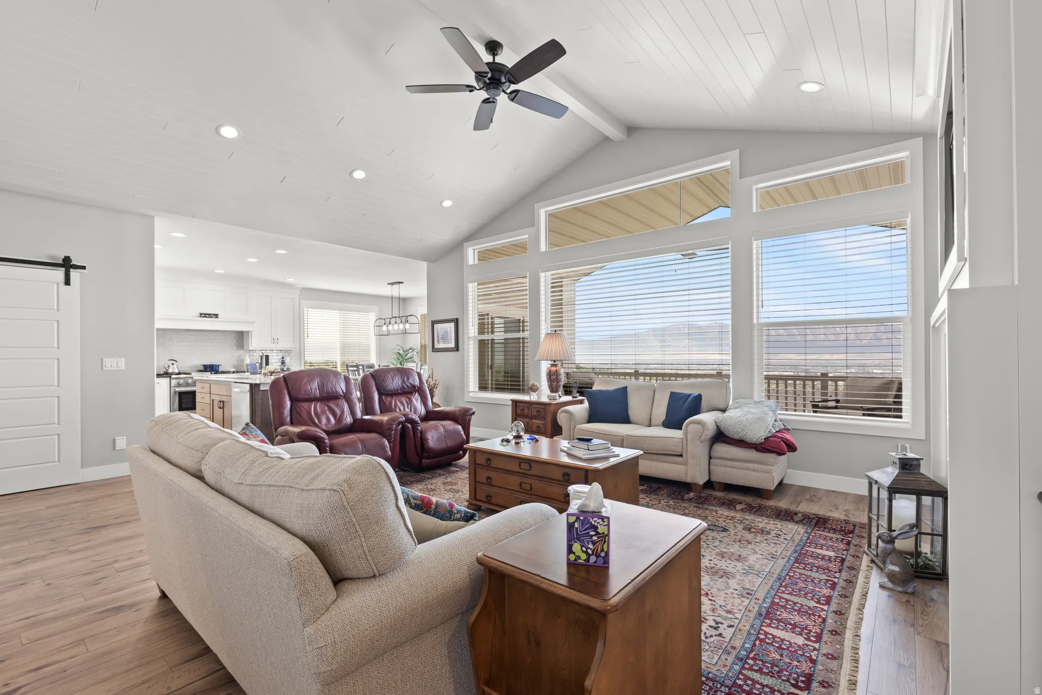 Spacious living area featuring vaulted ceilings with wood paneling, recessed lighting, and a contemporary ceiling fan