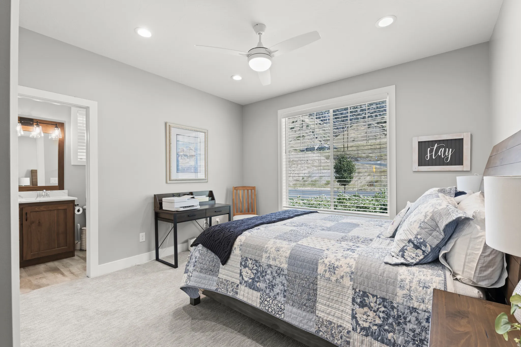 Carpeted bedroom with a window featuring horizontal blinds