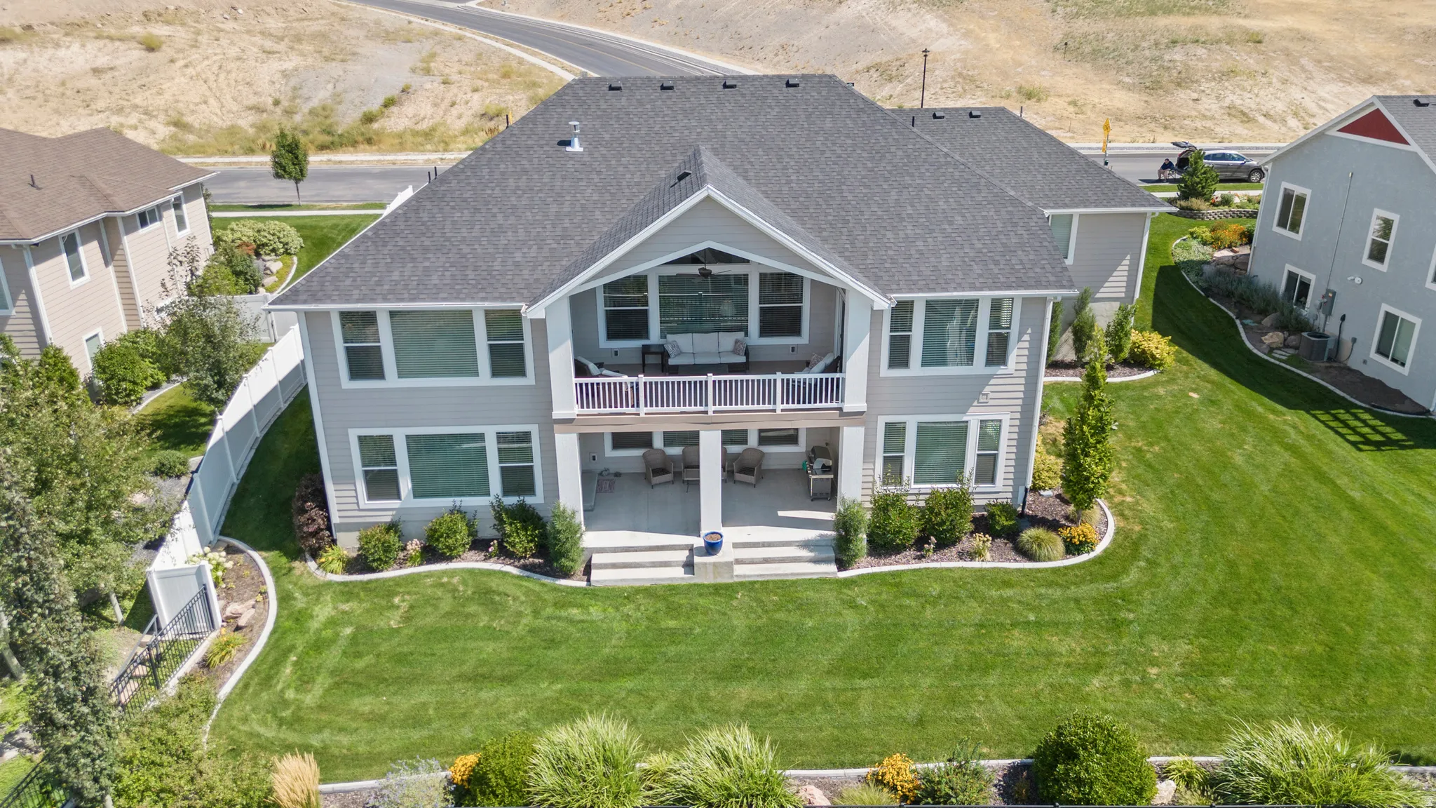 Rear elevation of a two-story home featuring light gray siding and a dark shingle roof
