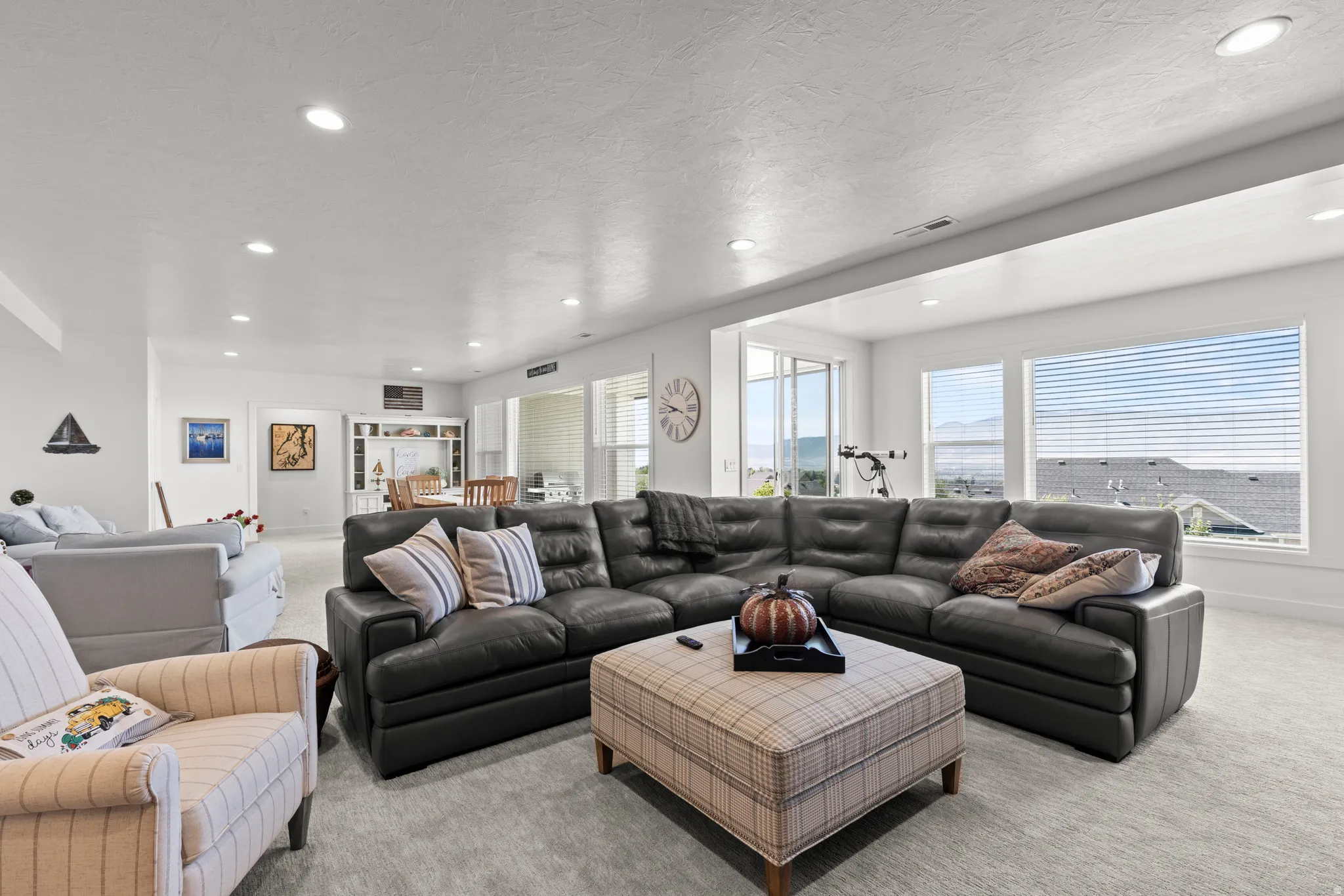 Spacious lower-level living area with recessed lighting and light-toned carpeting