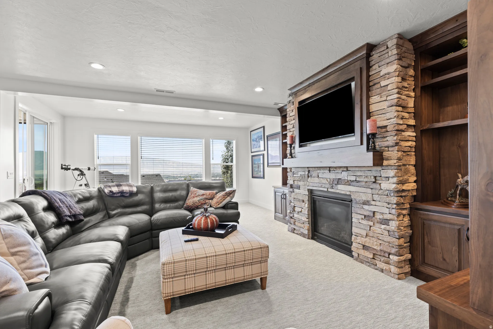 Living area featuring a stone-clad fireplace and built-in shelving