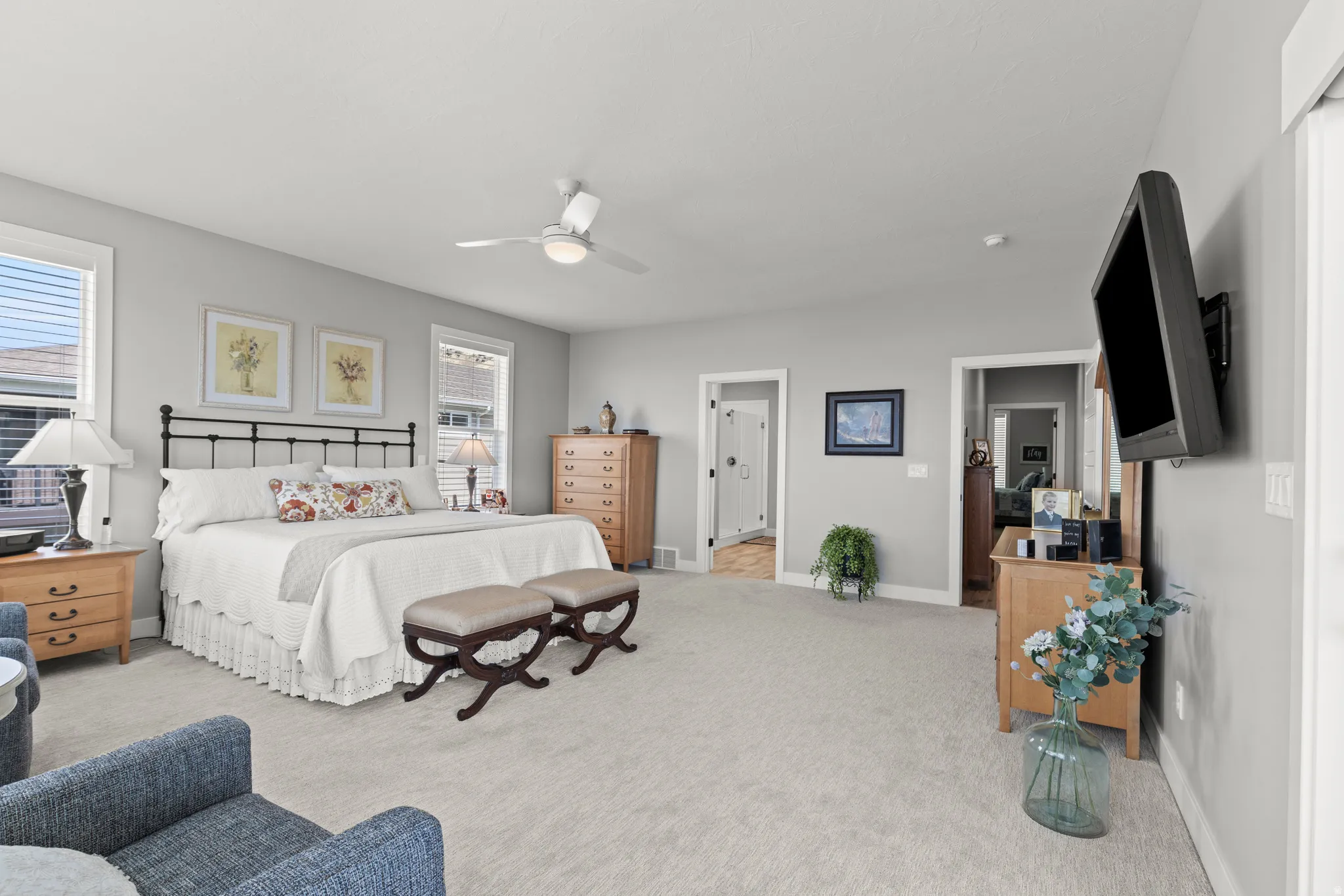 Spacious room featuring neutral carpeting, light gray wall paint, and multiple windows with blinds