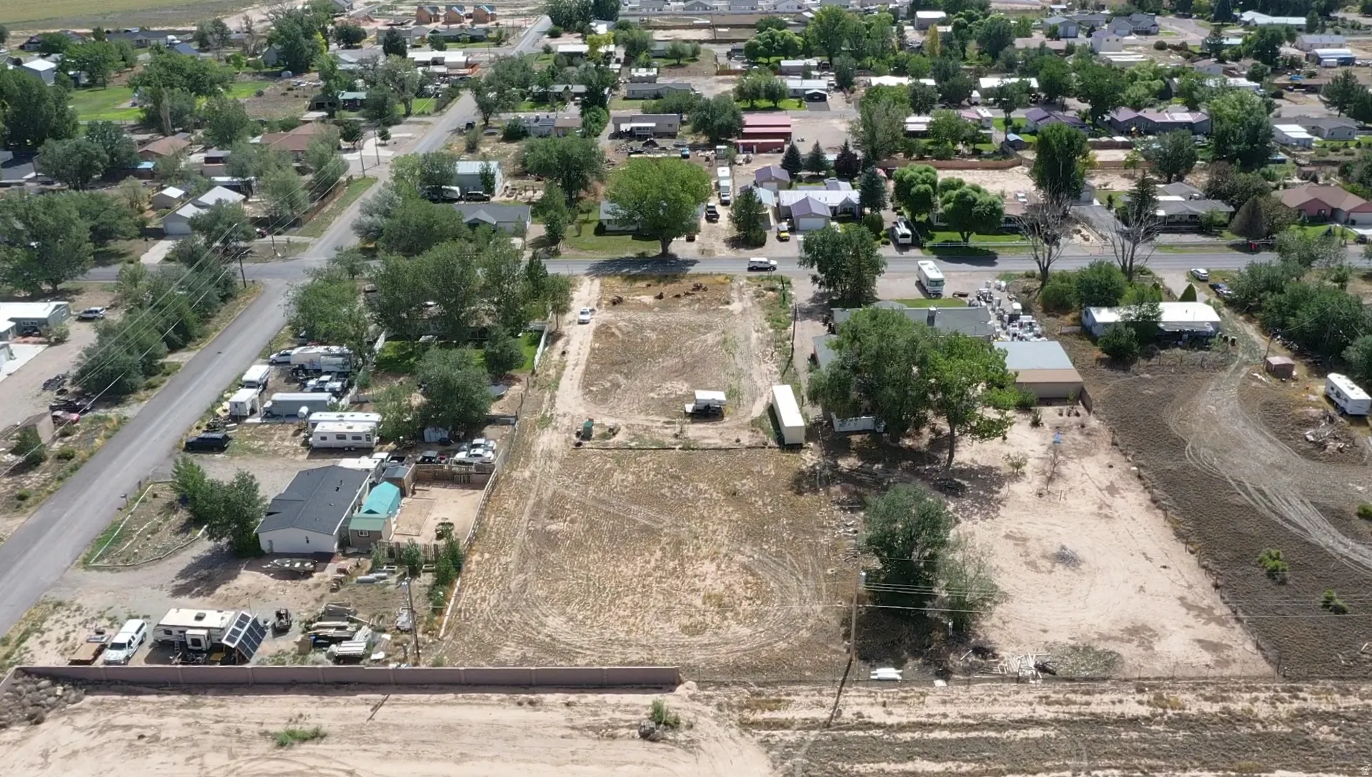 Expansive undeveloped land featuring mature trees and established residential surroundings