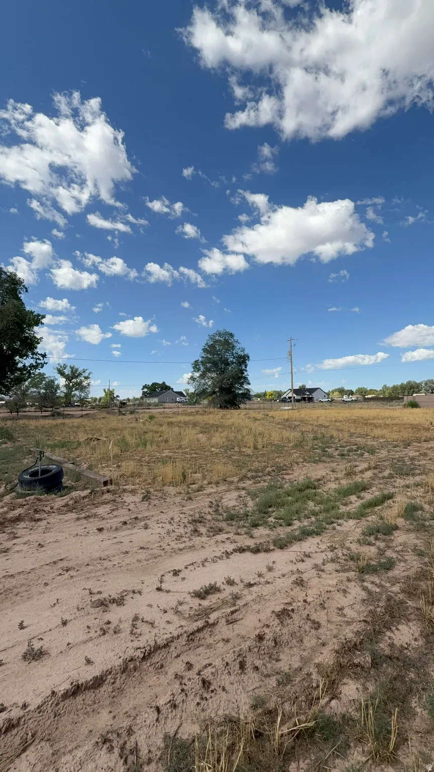 Expansive lot featuring a clear blue sky with scattered clouds