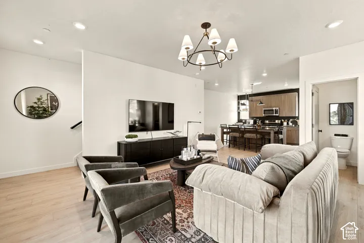 Open concept interior featuring wood-finish flooring, recessed lighting, multi-arm chandelier, and neutral wall color