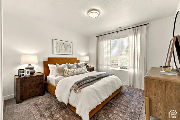 Room featuring neutral walls, wall-to-wall carpeting, and a large window with horizontal blinds