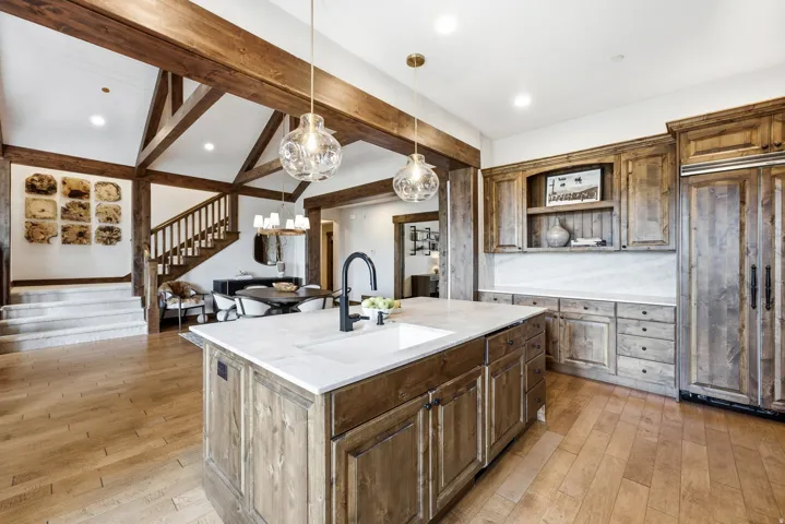 Spacious kitchen island with an undermount sink, light-toned countertop, and dark-stained cabinetry