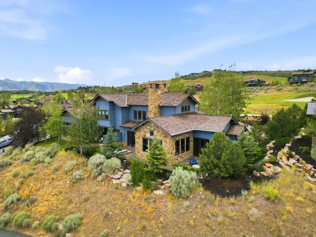 Multi-level residence featuring blue siding and natural stone accents